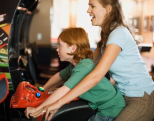 A young mother and her son play an arcafe game