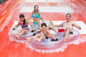 Family on a red watet slide at a water park