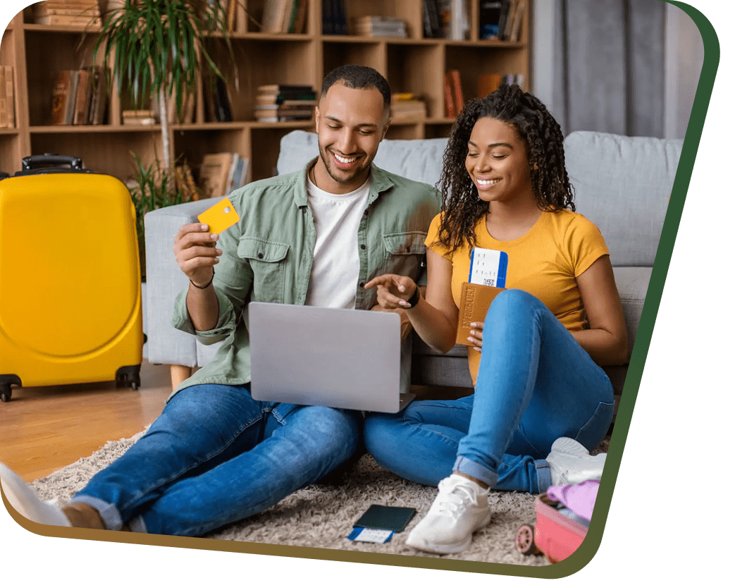 Couple booking travel online with laptop and passport