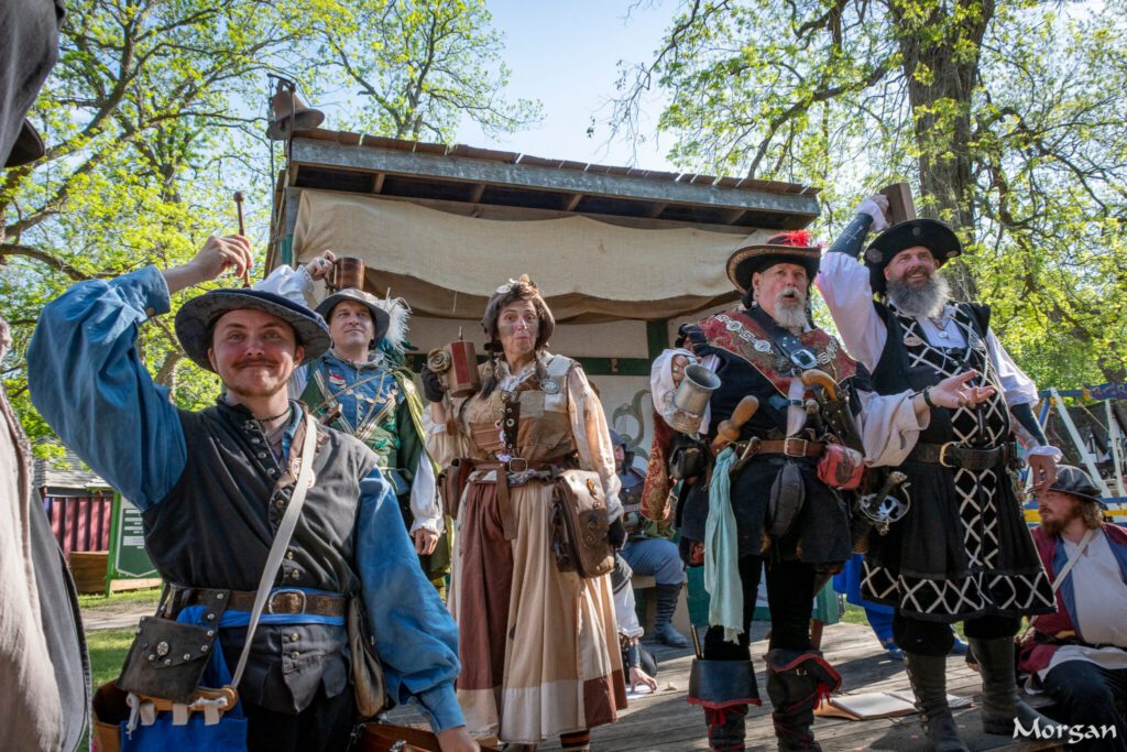 Renaissance fair participants in historical costumes outdoors.