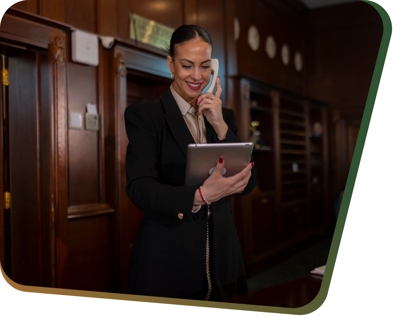 Woman on phone, holding tablet, in office.